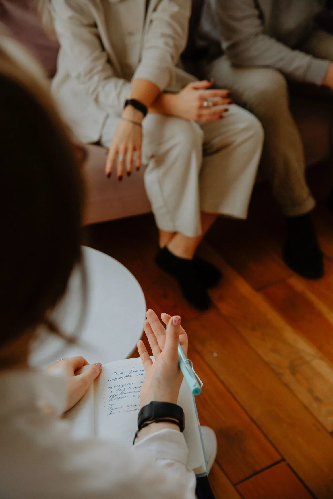A person listening and taking notes during a thoughtful conversation